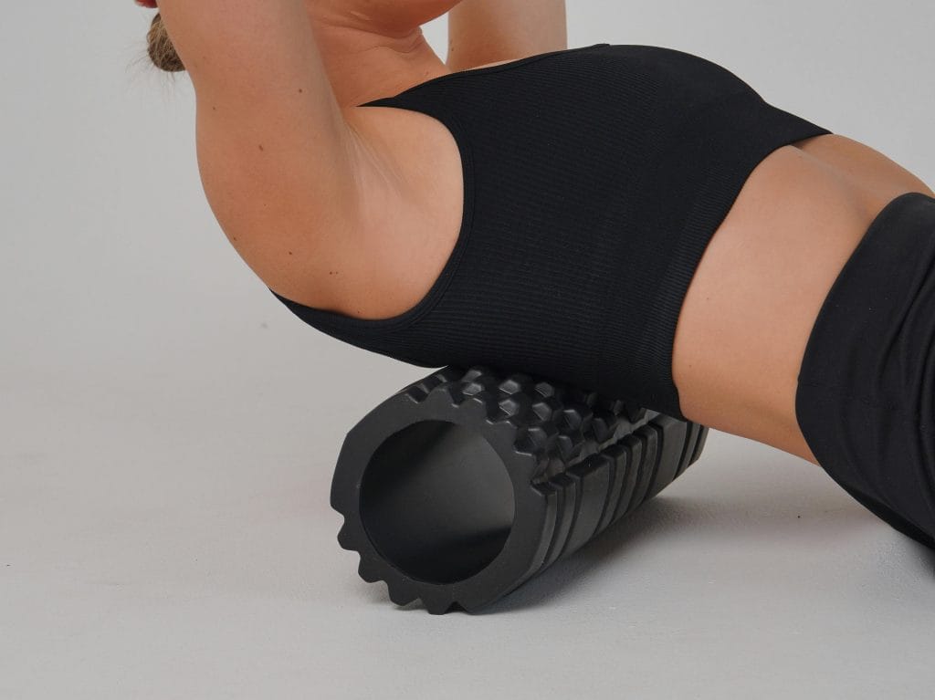 a woman demonstrating foam rolling