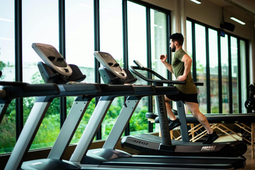 a man running on treadmills in a gym