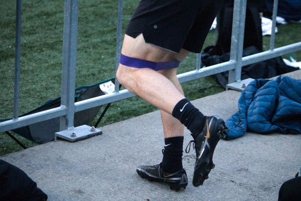 a person wearing black shorts and purple band
